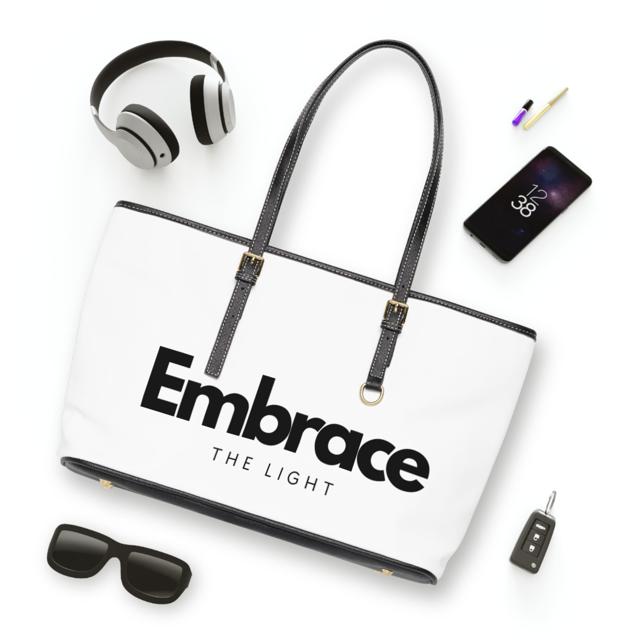 Stylish PU leather shoulder bag with 'Embrace the Light' text design, featuring black handles and gold accents. Spacious and durable for everyday use.