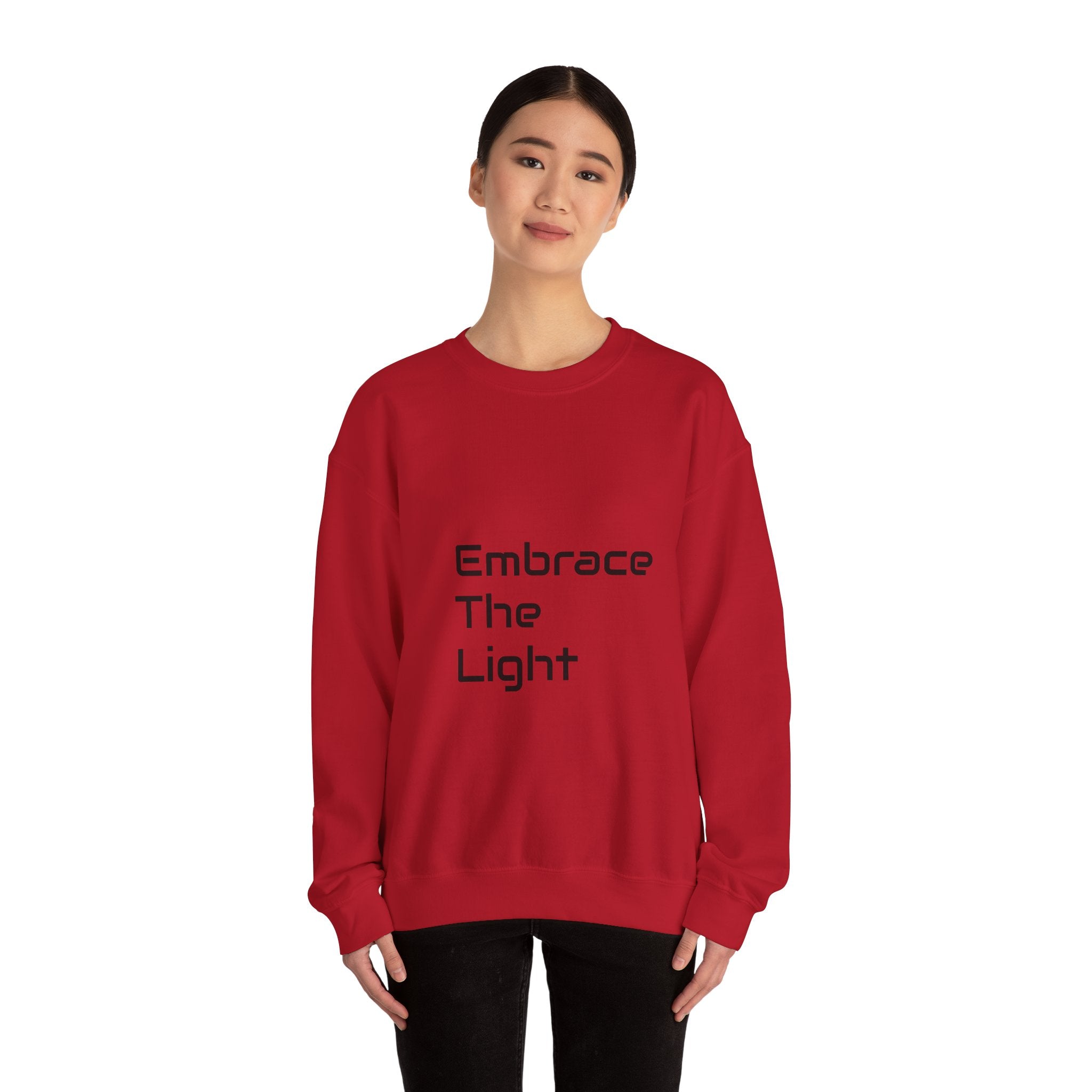 Unisex crewneck sweatshirt in red with 'Embrace The Light' text. Made from a cozy 50/50 cotton-polyester blend for comfort and durability.