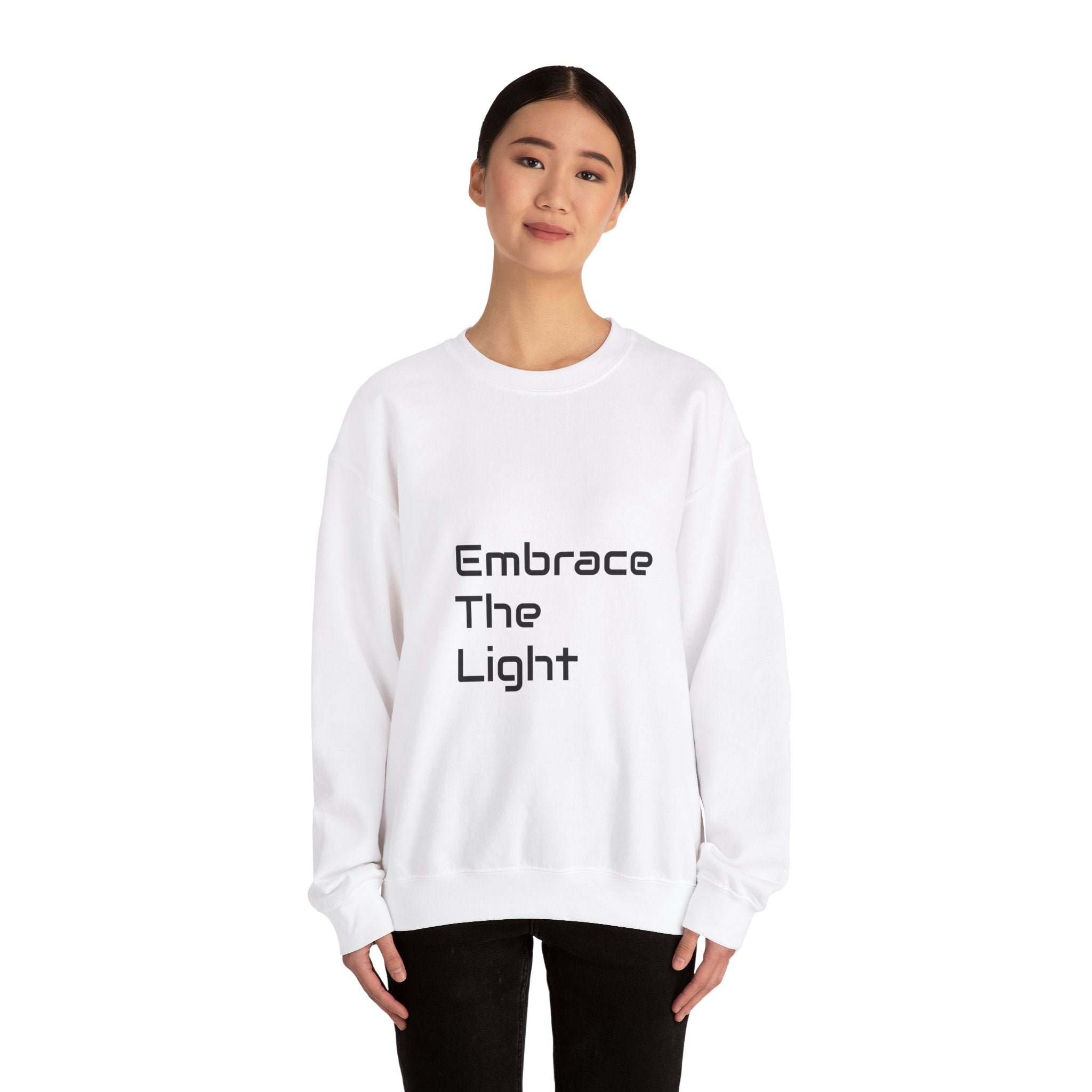 Unisex crewneck sweatshirt in white with 'Embrace The Light' text design. Made from a soft cotton-polyester blend for comfort and durability.