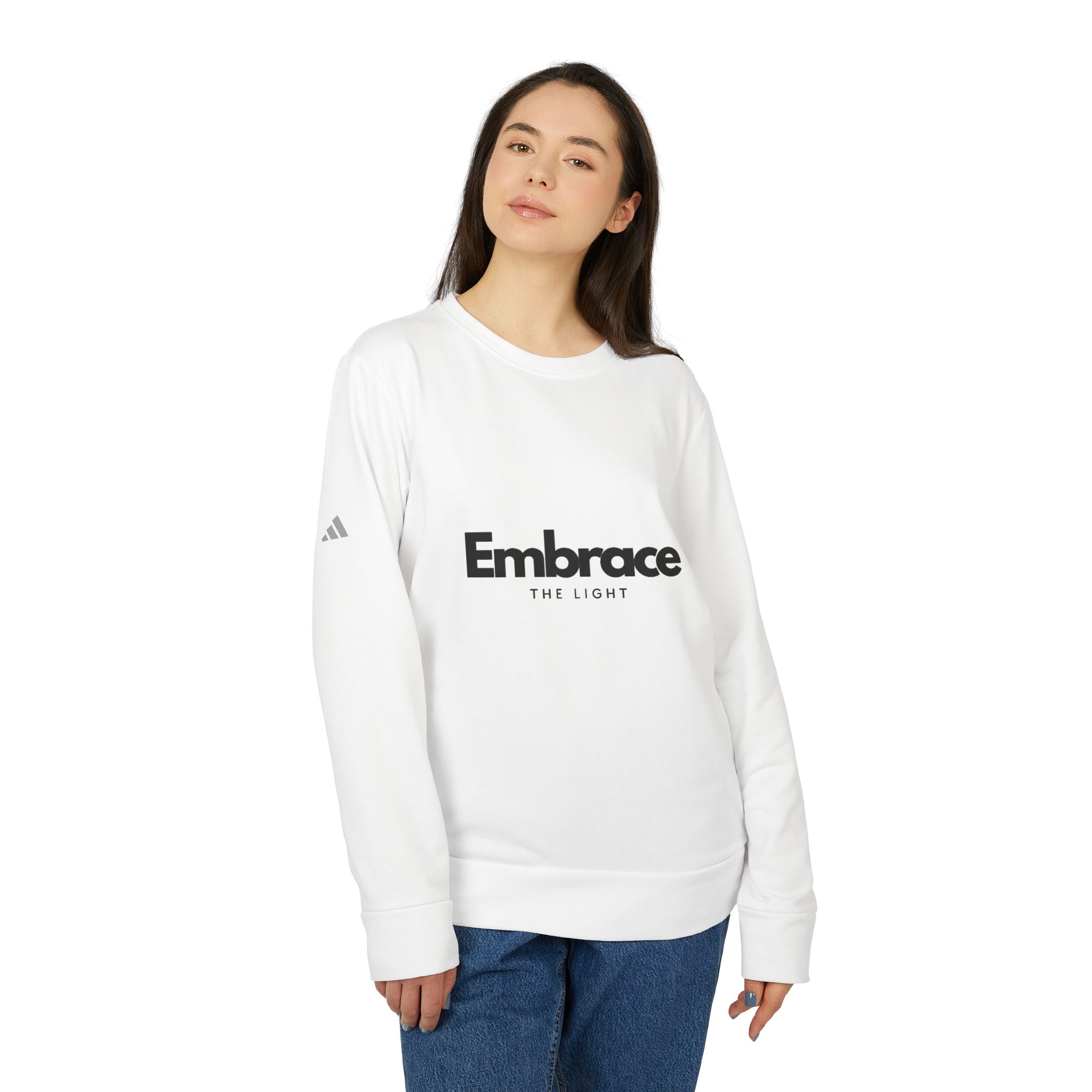 Adidas fleece sweatshirt in white with 'Embrace The Light' print. Eco-friendly crewneck made from BCI cotton and recycled polyester for warmth and sustainability.