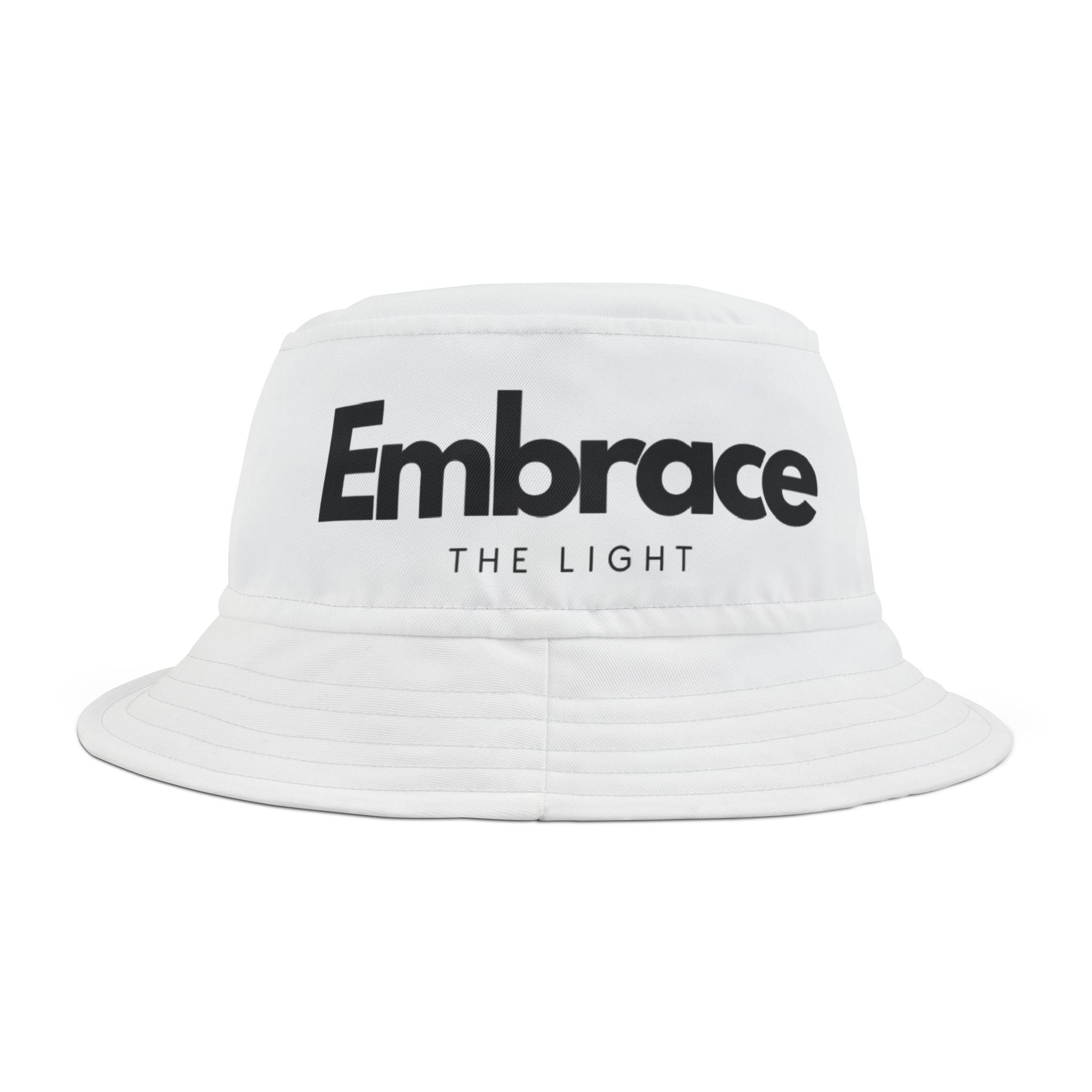 White bucket hat with 'Embrace The Light' text design in bold black font. Made from 100% polyester, stylish and modern for all fashion trends.